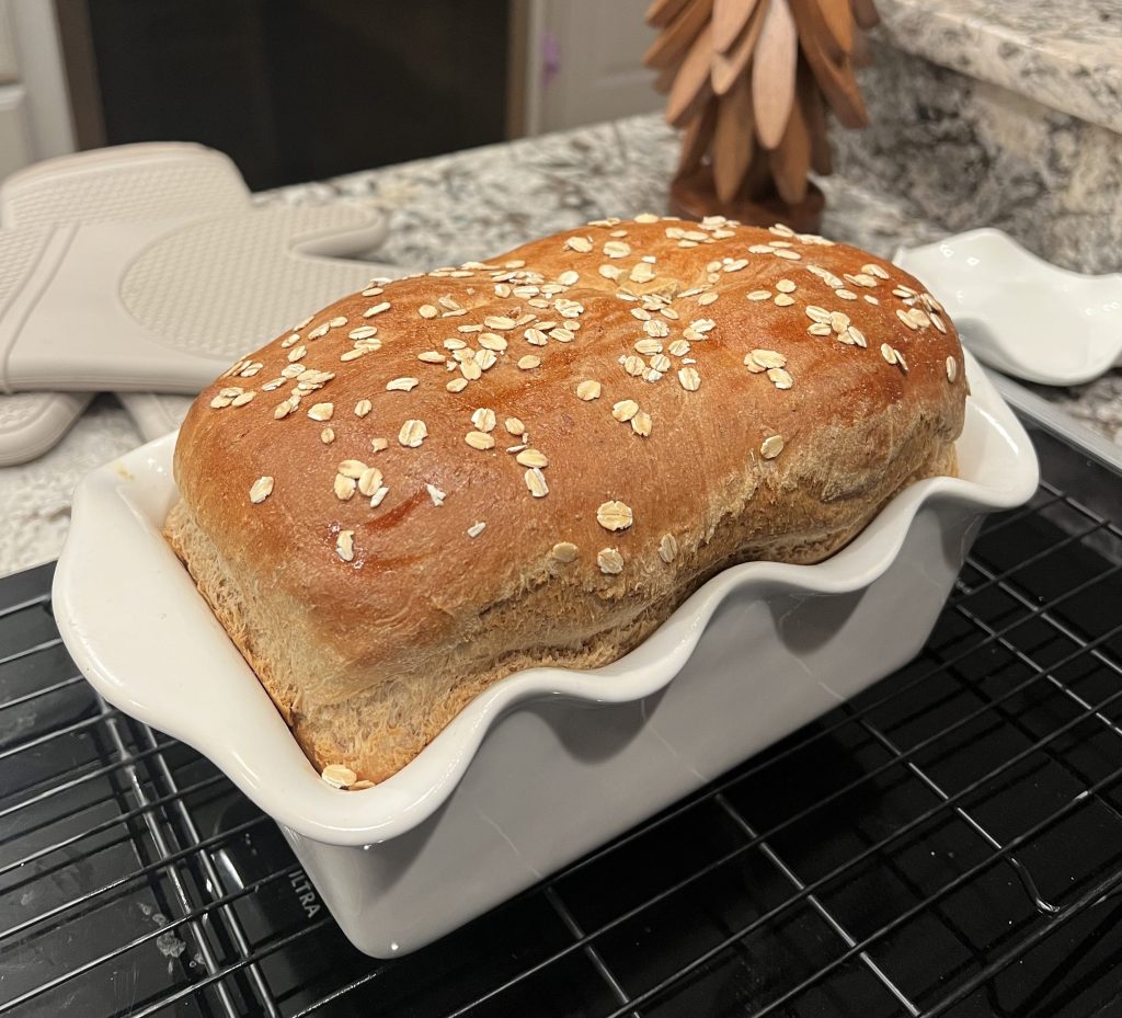 Freshly baked oatmeal wheat sandwich bread in a loaf pan