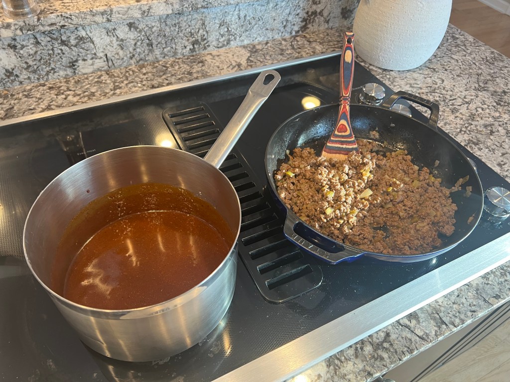Beef enchilada meat and mild enchilada sauce cooking on the stovetop