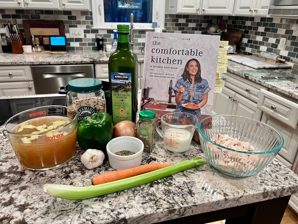 The Comfortable Kitchen cookbook by Alex Snodgrass with ingredients for chicken and wild rice soup