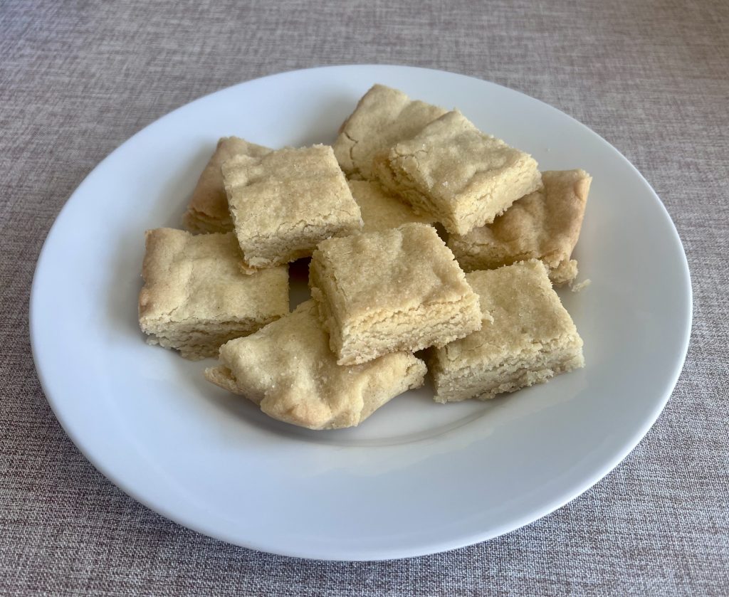 Cut vanilla bean shortbread bars plated after baking, showing a buttery, crumbly texture.