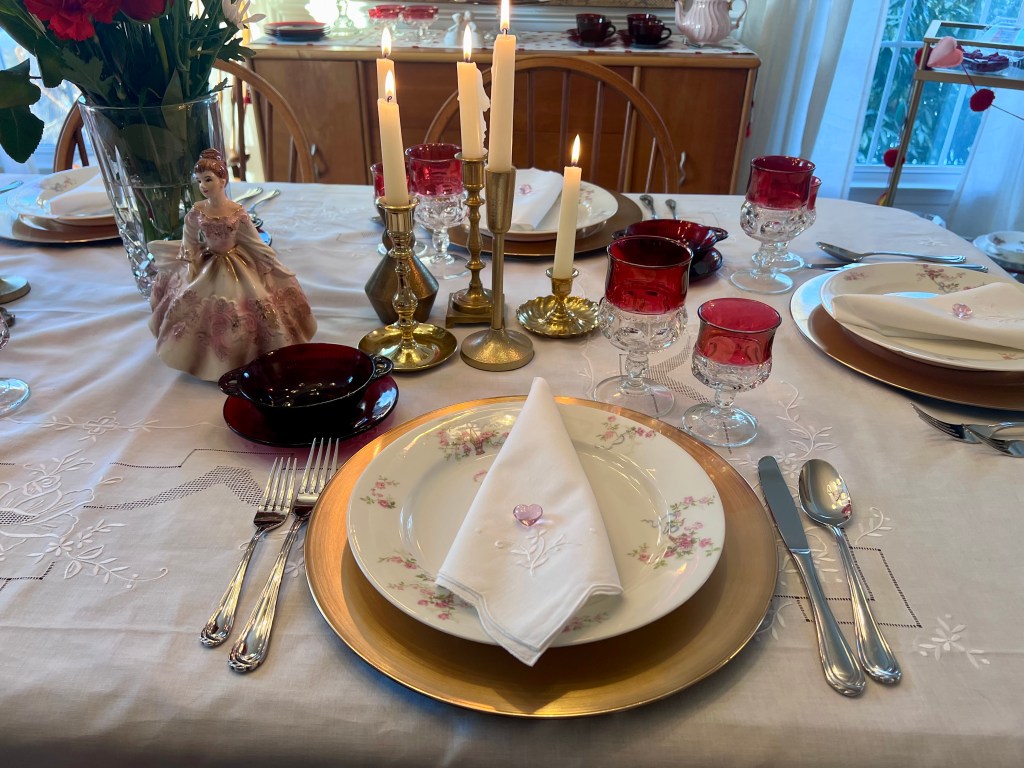 Antique Limoges dinner plate layered on white heirloom linens with ruby King’s Crown wine glass and vintage flatware for a Valentine’s Day table setting.