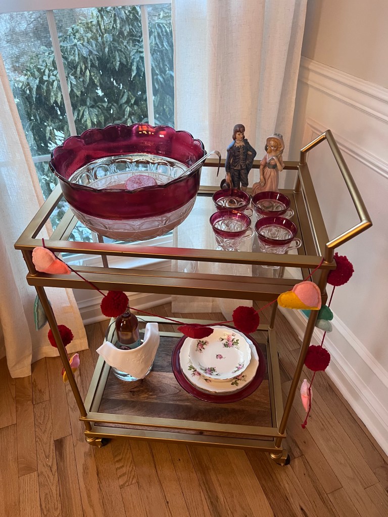Ruby Indiana Glass Lexington punch bowl filled with pink Valentine’s Day punch, surrounded by matching vintage glasses on a white linen table.