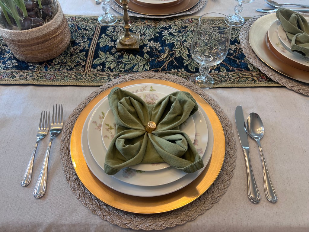 St. Patrick’s Day place setting with Schleiger 79 china, gold charger, and napkin folded into a clover