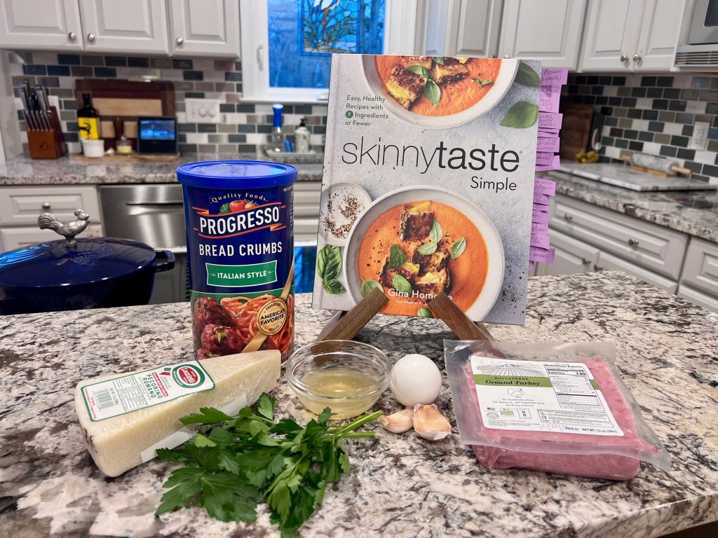 Skinnytaste Simple cookbook on kitchen counter with ingredients ready for turkey meatballs