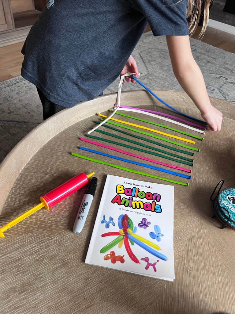 Balloon animal making kit and Sharpie laid out on table for balloon animals kids activity