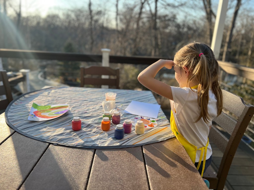 Child looking at backyard view for inspiration before painting outside