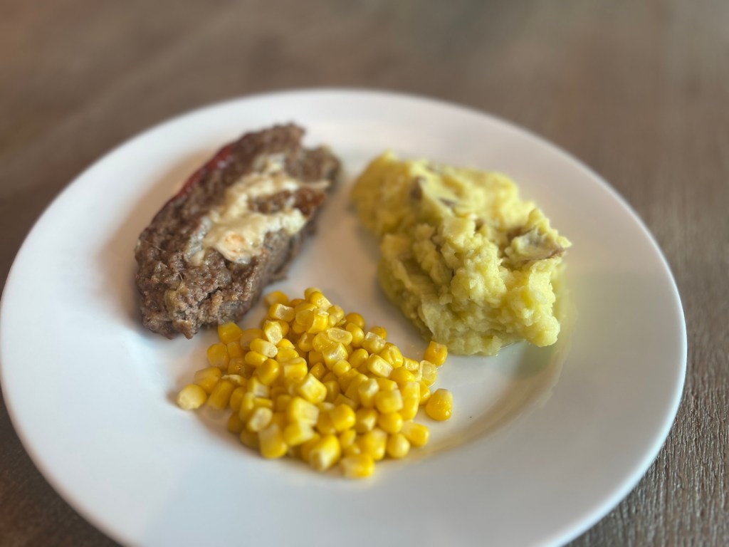 Mozzarella-stuffed meatloaf served with mashed potatoes and corn