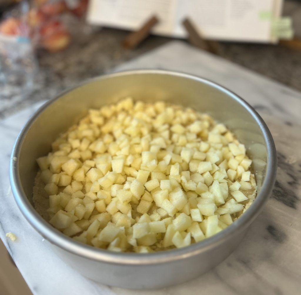 Layering Irish apple cake with chopped apples over the bottom dough layer before adding the top crust and baking