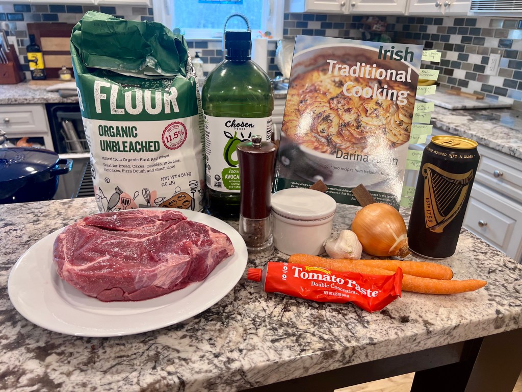 Ingredients for Guinness beef stew with Irish Traditional Cooking cookbook by Darina Allen on the counter before cooking