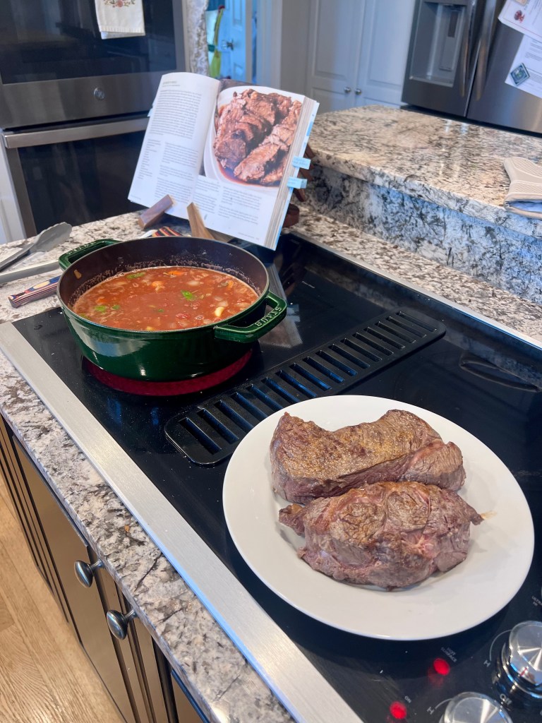 Barolo braised beef sauce simmering with sliced chuck roast resting before roasting in Dutch oven