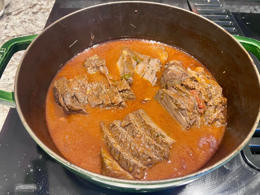 Barolo braised beef sliced and served in red wine sauce, tender fall apart chuck roast in Dutch oven