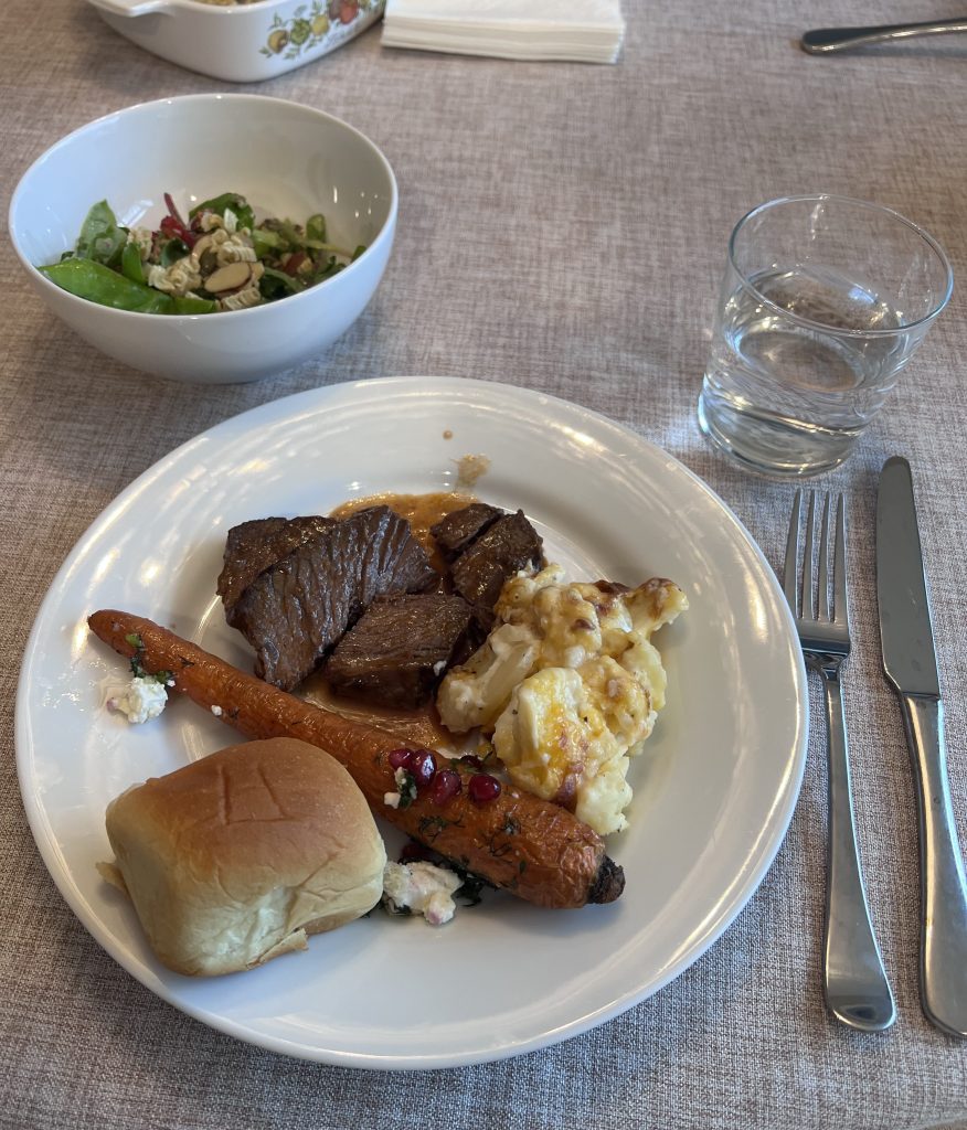 Barolo braised beef dinner plate with scalloped potatoes, roasted carrots, and strawberry salad